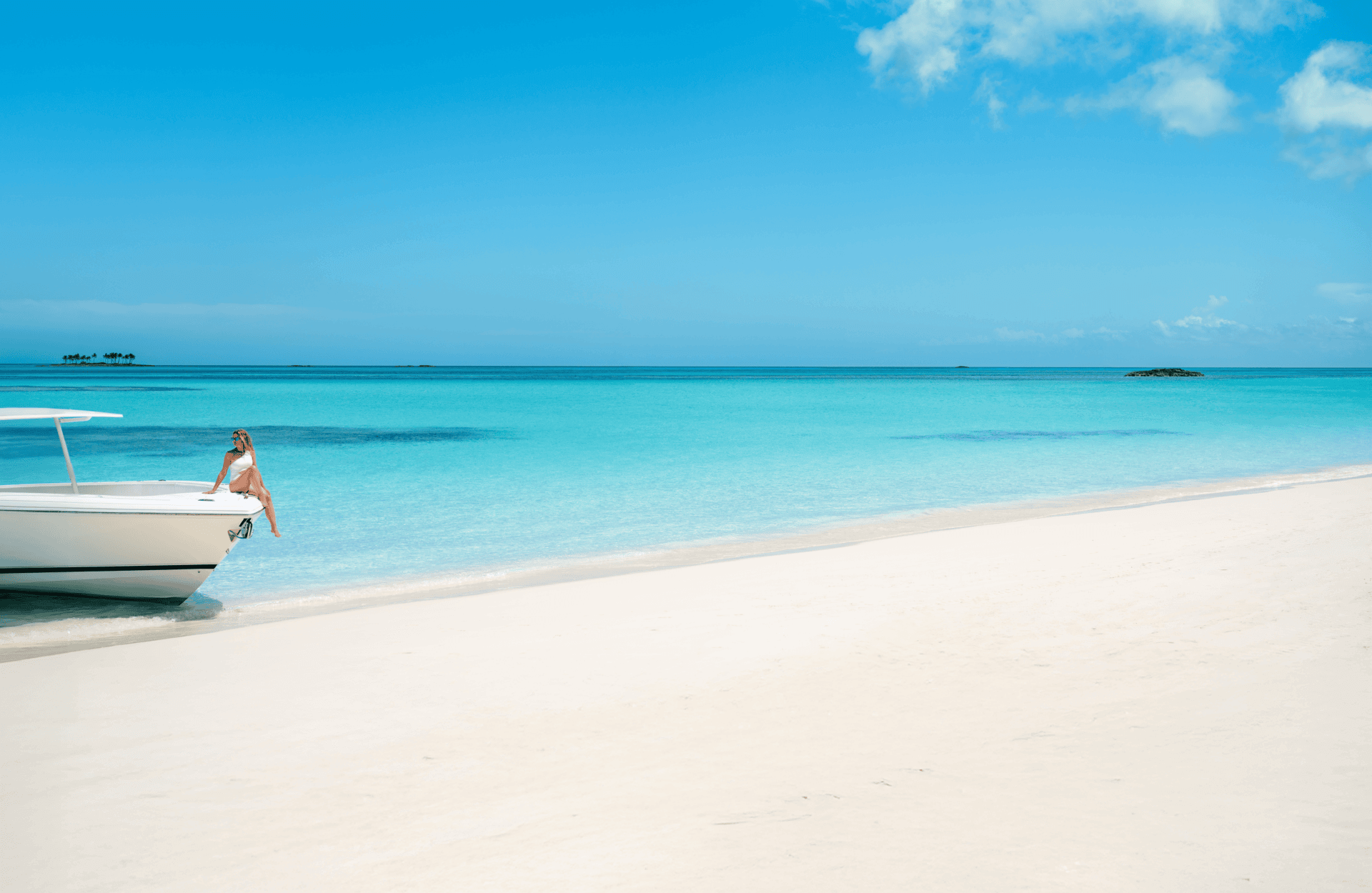 Girl sitting on boat that is on the beach